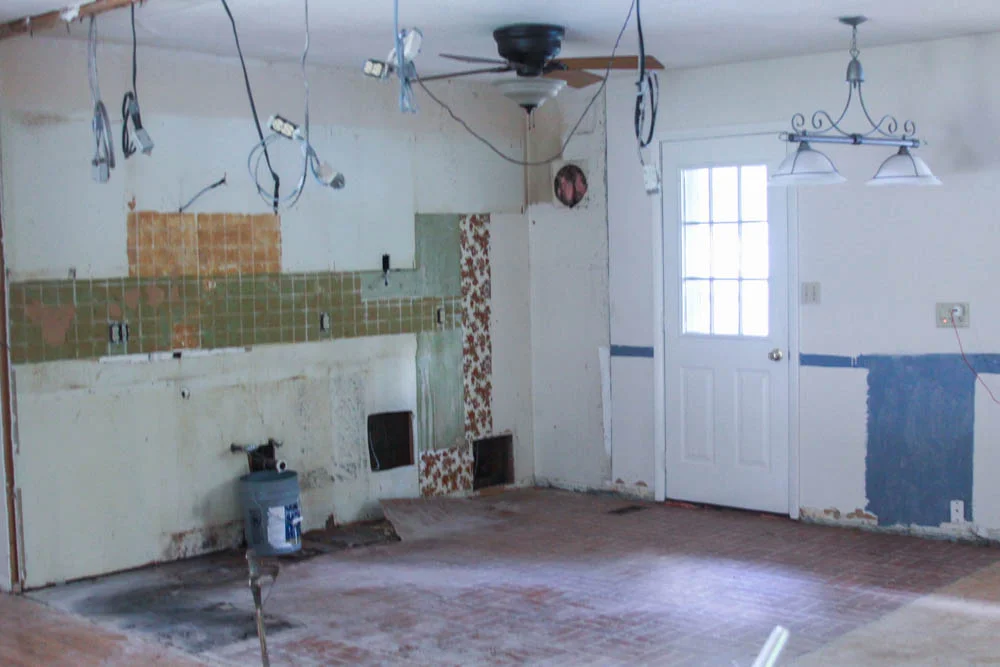 Here is a picture of what the kitchen looked like after we had taken out all the cabinets, removed a wall (hence the hanging electrical), taken out the backsplash, and ripped up all the flooring.