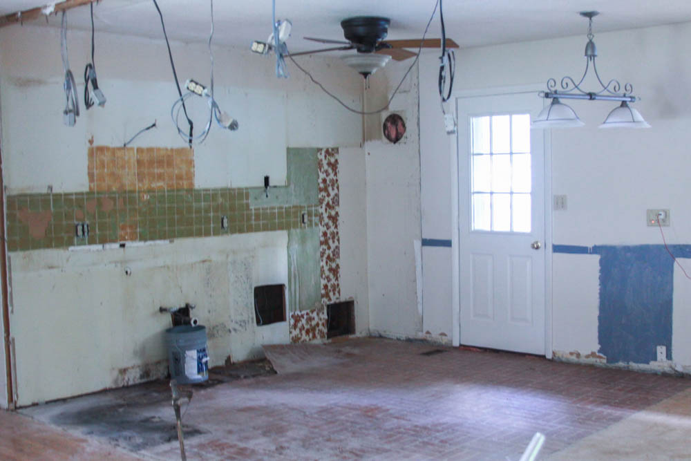  Here is a picture of what the kitchen looked like after we had taken out all the cabinets, removed a wall (hence the hanging electrical), taken out the backsplash, and ripped up all the flooring. 