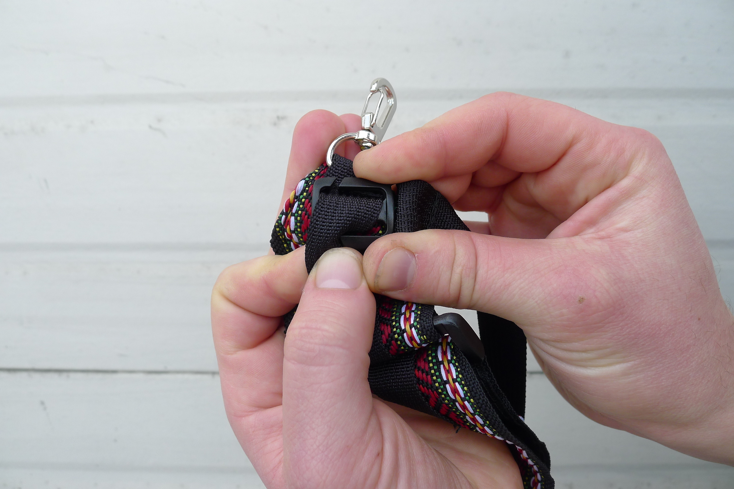 Remove cross strap by slipping the webbing through the plastic slits