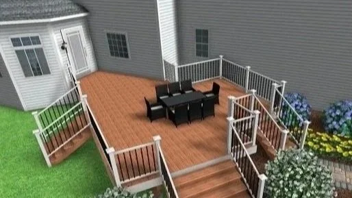 A backyard deck design with table and chairs, attached to a house with white siding, surrounded by a white railing and decorated with flowers.