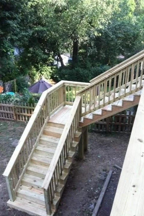 This picture illustrates a large wooden set of steps with a landing.