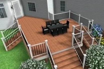 Elevated backyard deck with a black outdoor dining table and chairs, surrounded by white railing, with stairs leading down to a grassy area.