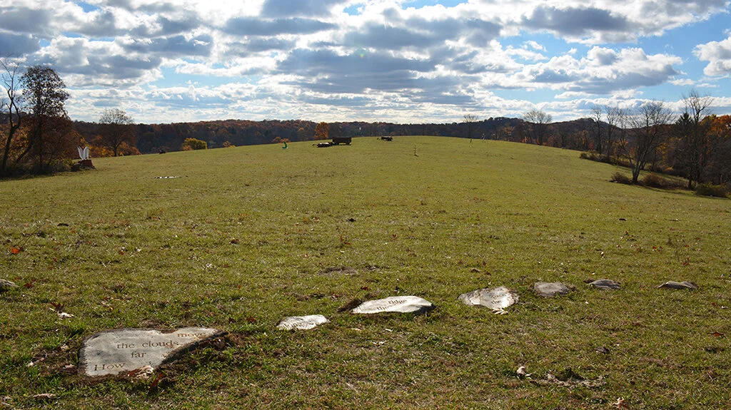 in the space ofGranite schist, clouds, ridge, breath.Hand-carved rocks of the same mineral composition as the distant ridges were embedded in the Hudson Highlands, Garrison. NY in view of a distant ridge.Text by the artist:How far the cloudsmove alo…