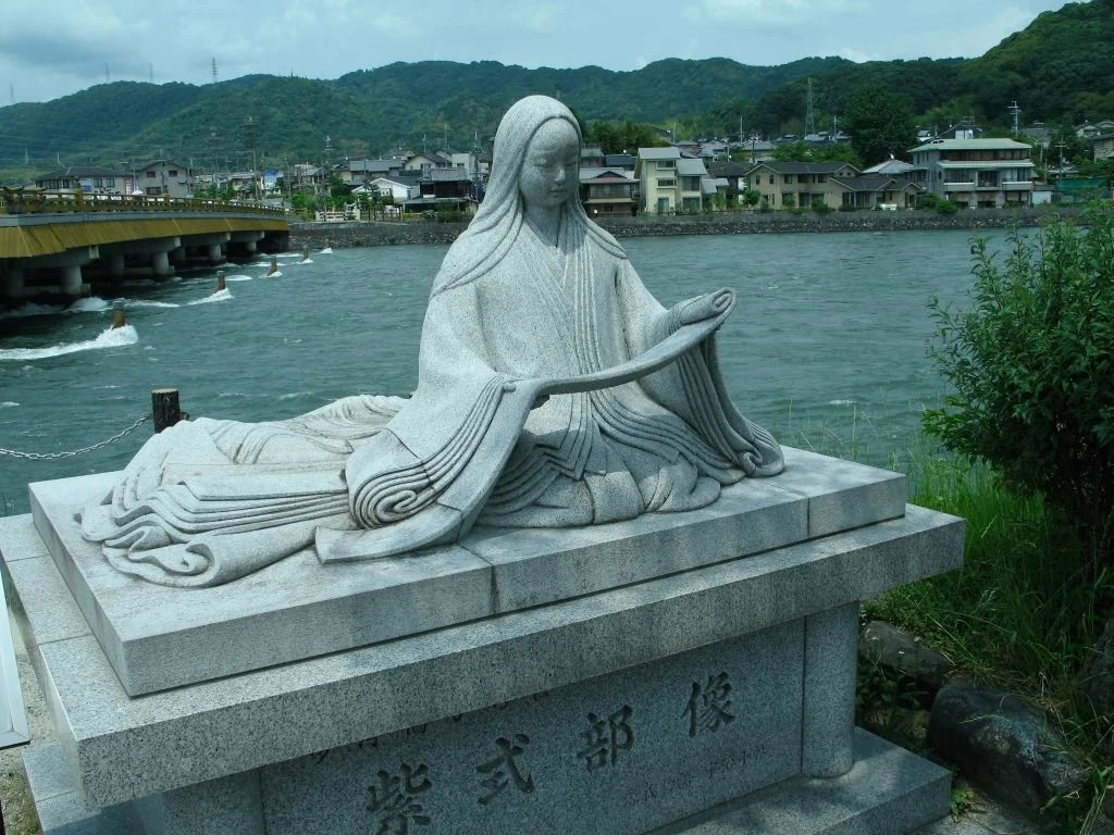 Statue of Murasaki Shikibu, author of Tale of Genji, perched over Uji river.