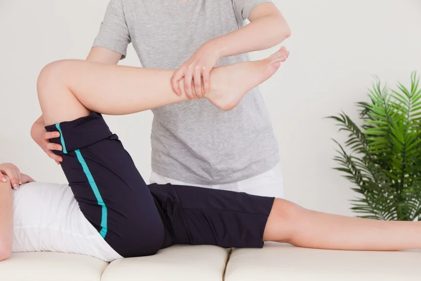 Masseuse stretching the right leg of a young woman.jpeg