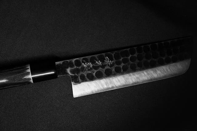Object of passion no.1; Mutsumi Hinoura&rsquo;s Nakiri (vegetable knife). Mutsumi is the 4th generation of the famous Hinoura from Sanyo. Made from super pure Shirogami White Paper steel as a core, and a soft iron Kurouchi style hammered cladding to aid with food release. ⁣The handle is made from burnt Chestnut and water buffalo horn ferrule. One of my favourite tools in the kitchen. (Sony &alpha;6300, 35mm f/1.8 OSS) #a6300 #sonya6300 #sonyalpha #justgoshoot #sonyimages #sonygallery #ifyouleave #japaneseknives #VSCO #trix400