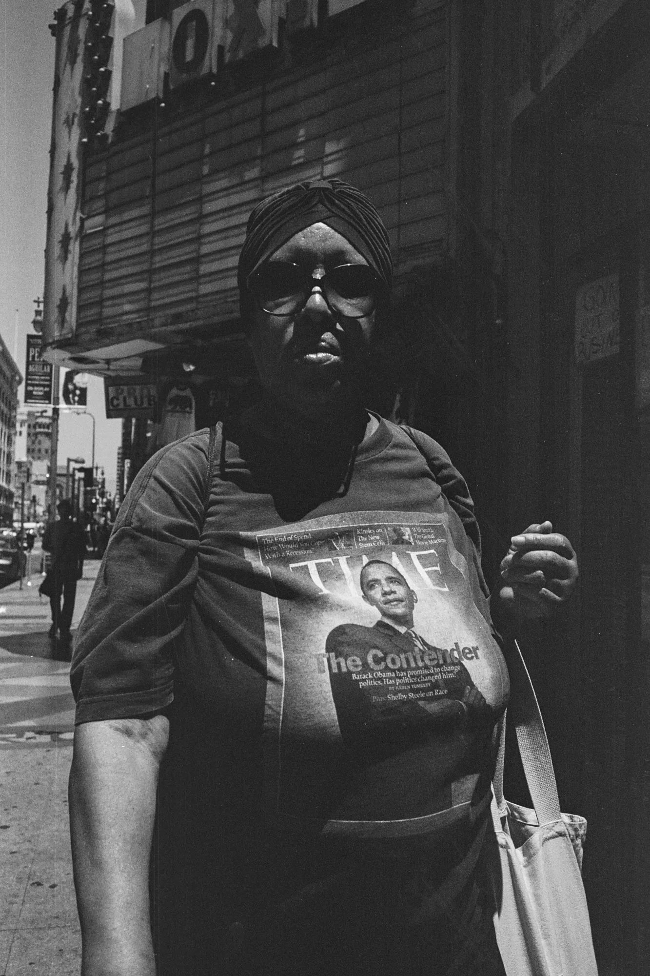 Woman wearing shirt with Time Magazine cover of President Obama walking on the streets of Downtown LA, CA - 2014