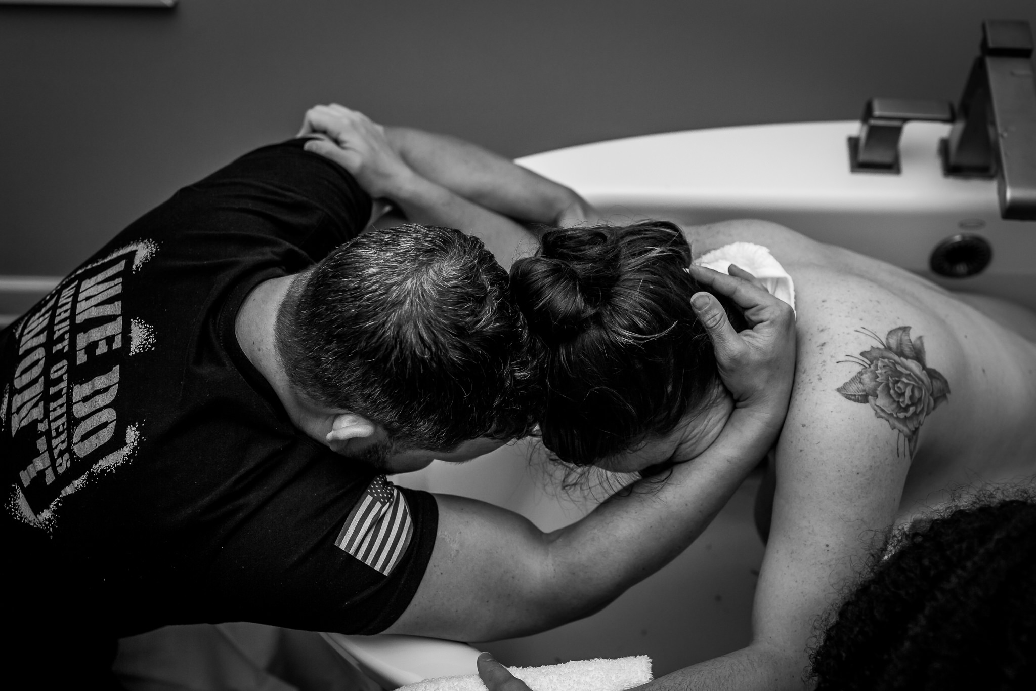 dad holding helping mom through water birth contraction