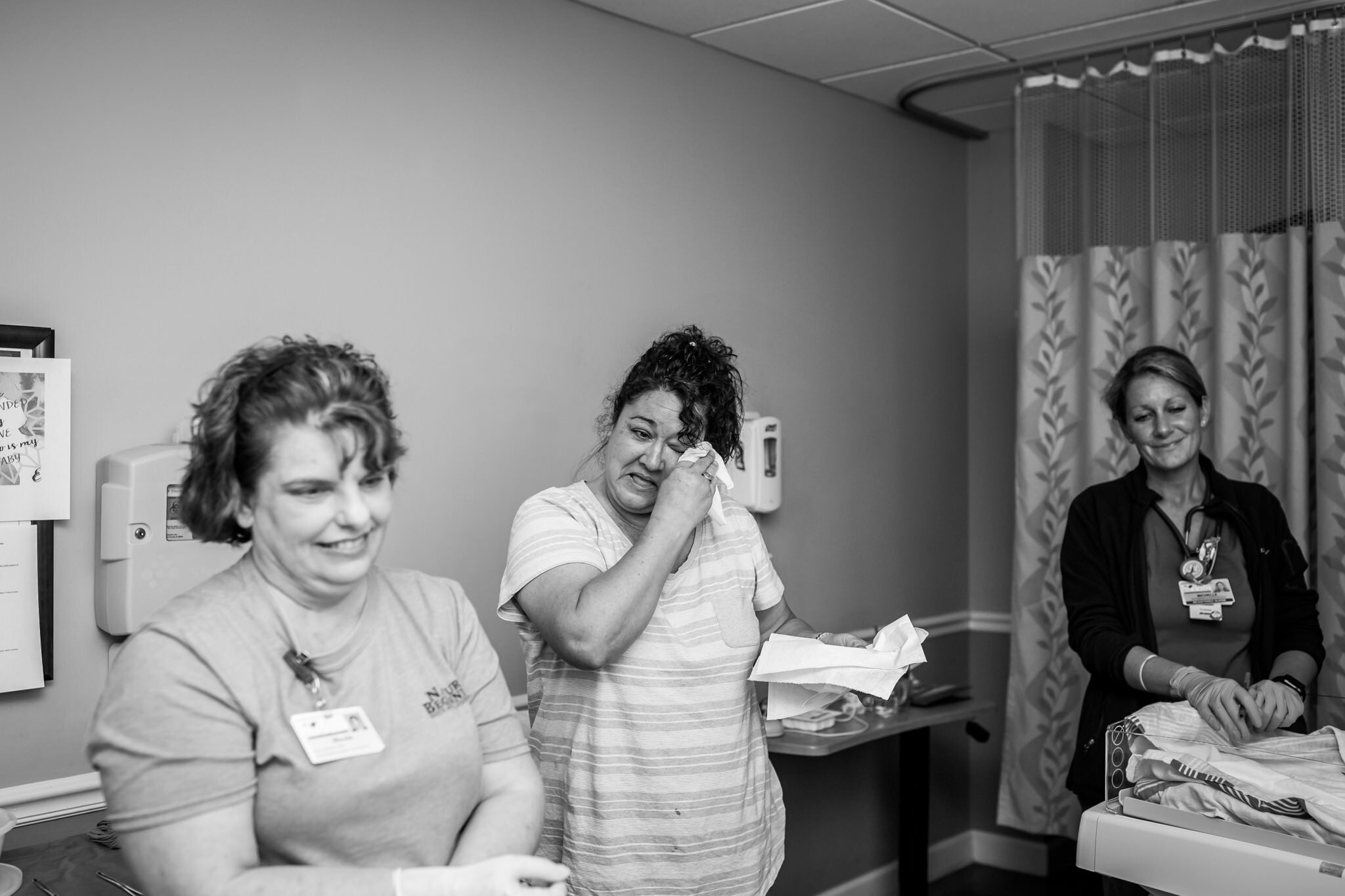 grandma cries while midwife looks on during hospital birth