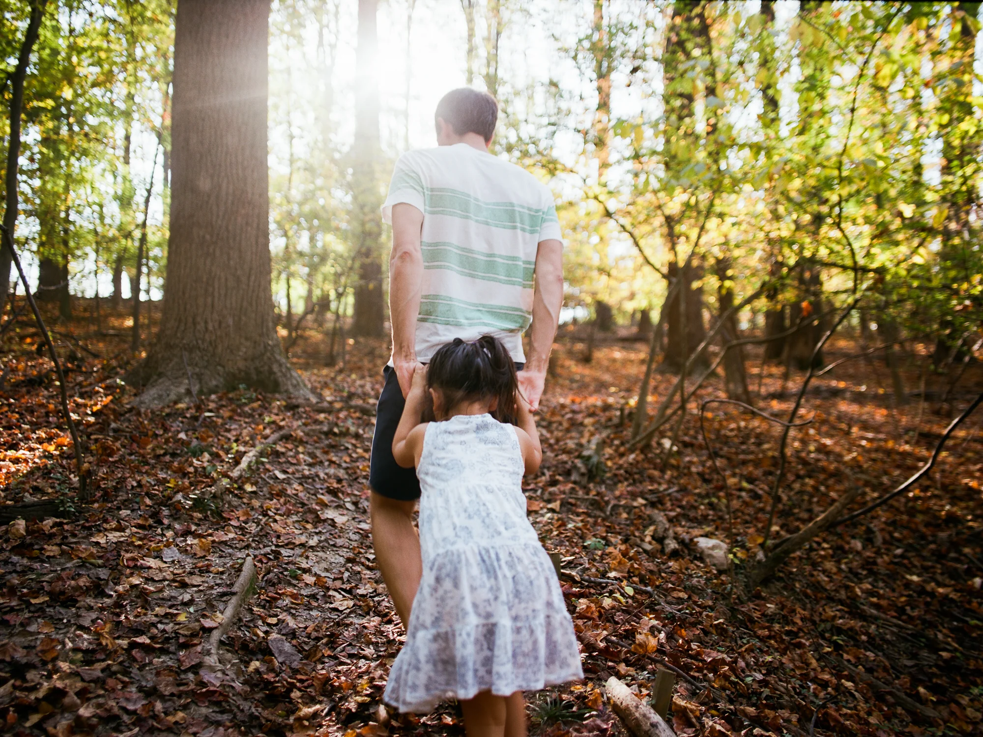 Dad and daughter hike through woods during Ventura Family Photography session