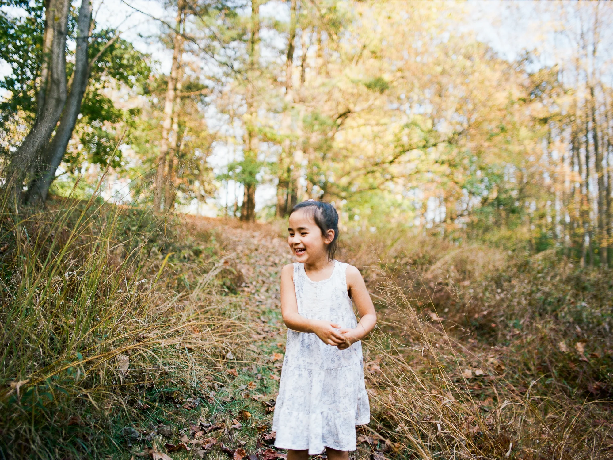 Girl laughs in forest during Ventura Family Photography Session