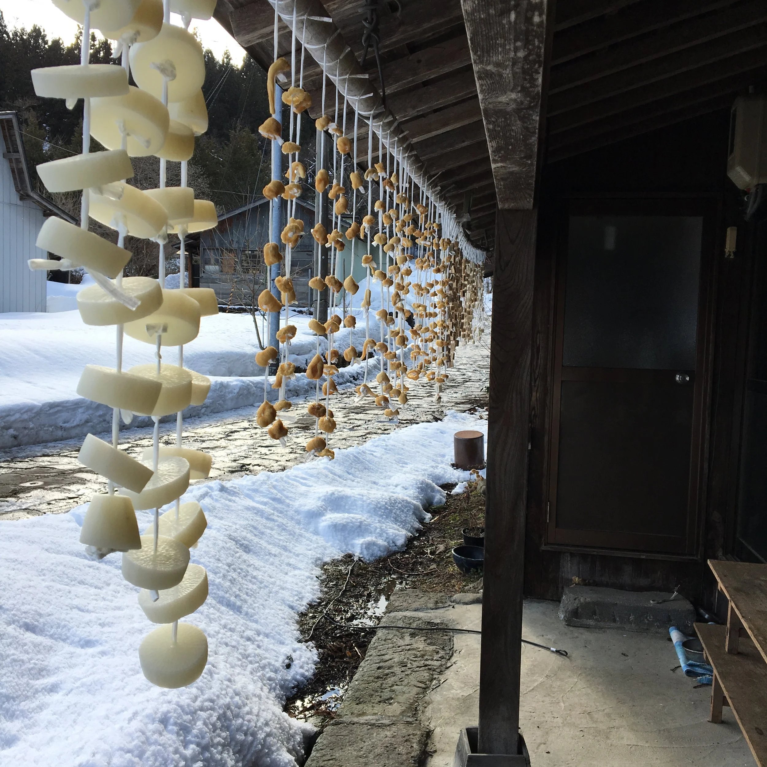 軒下で干されている凍み大根。奥は凍み餅。