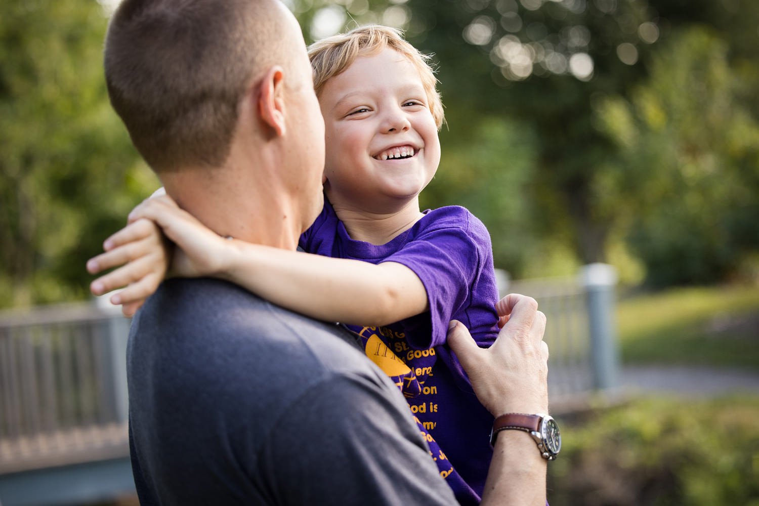 Natural family photography highlighting joyful moment between dad and child