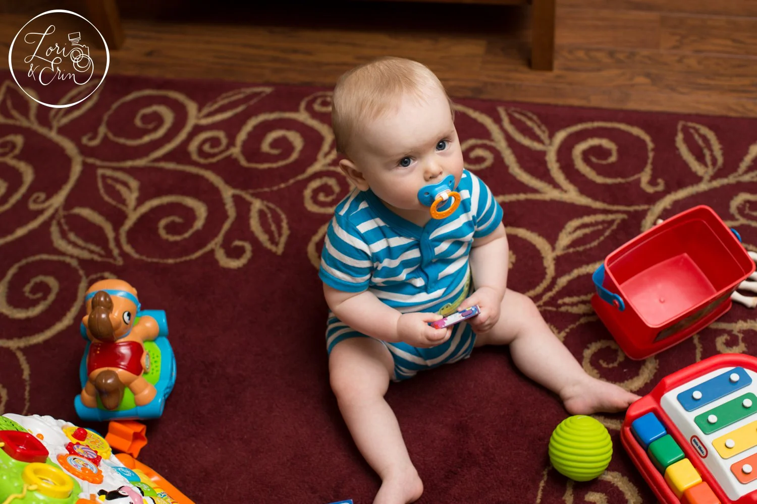This image shows Lucas surrounded by his toys, but he is less interested in looking up at the camera, he looks small in the space and it is not nearly as engaging as the first image.