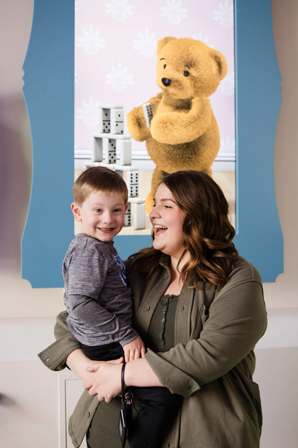Mother holding young son during candid family pictures at The Strong Museum of Play in Rochester NY