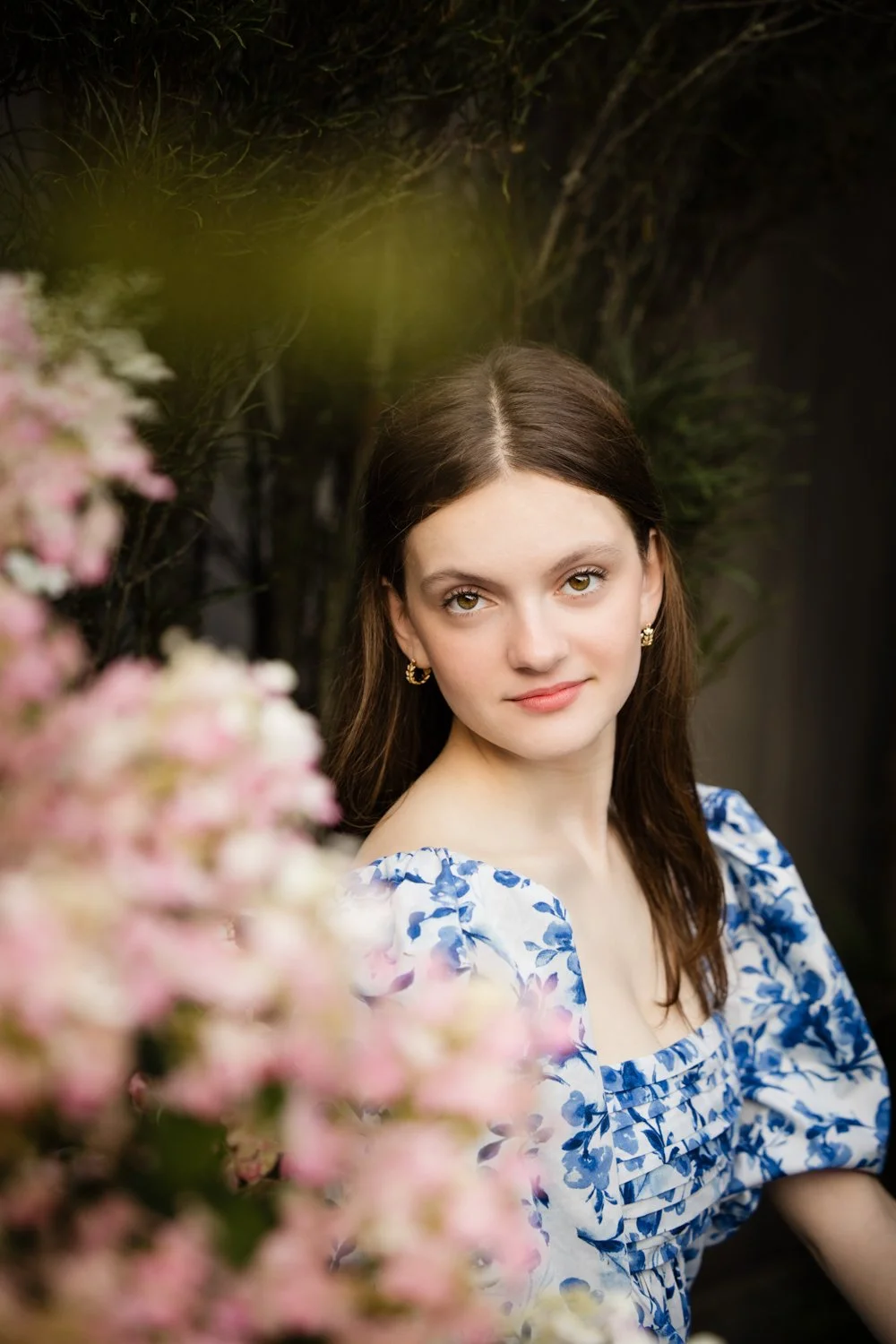 Senior photo session in Brighton NY capturing senior surrounded by pink and white flowers