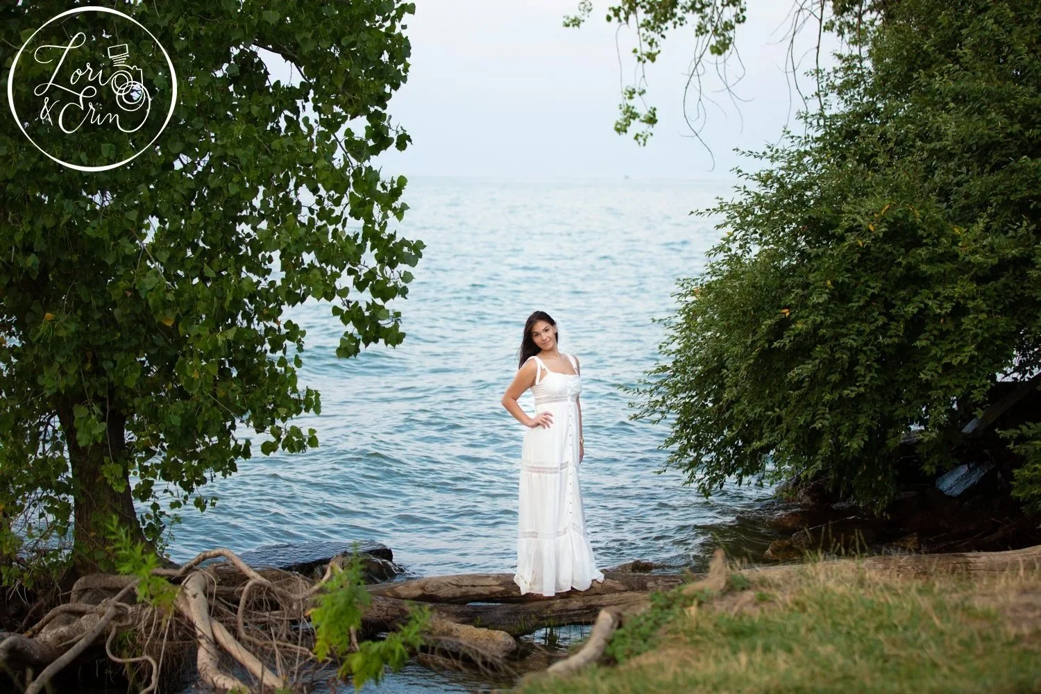 A high school senior portrait of a girl on a log over water at Durand Eastman Park in Rochester NY