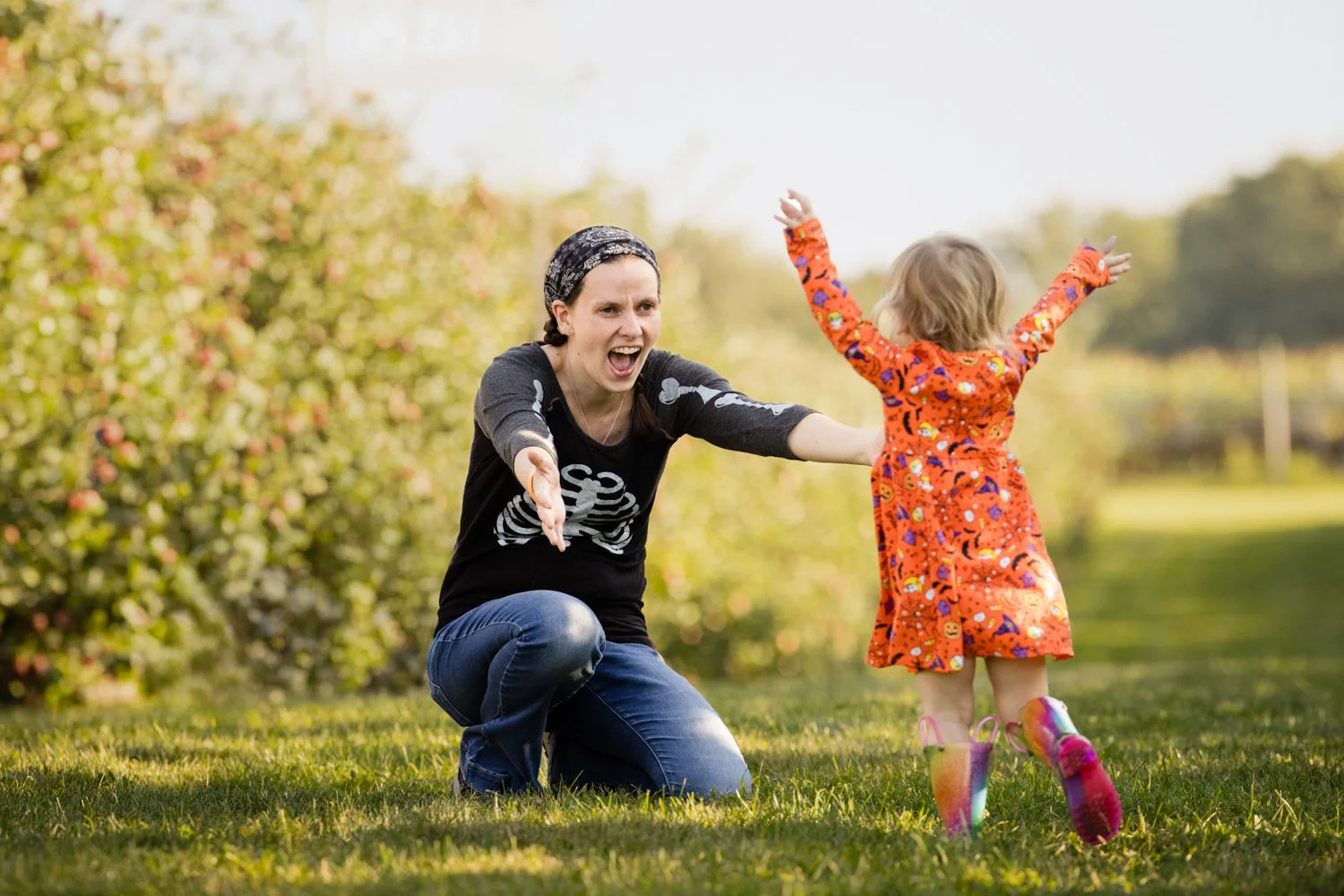 Candid family pictures at Wickham Farms in Fairport NY capturing playful moment between mom and daughter during apple picking
