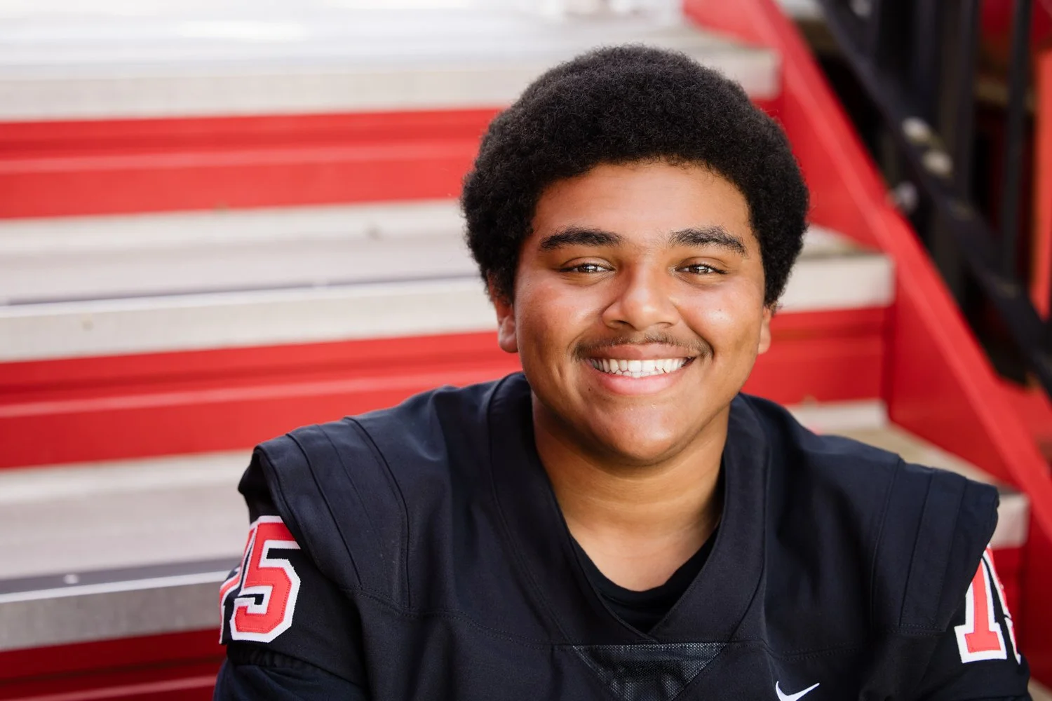 Penfield NY senior pictures featuring high school football player on bleachers