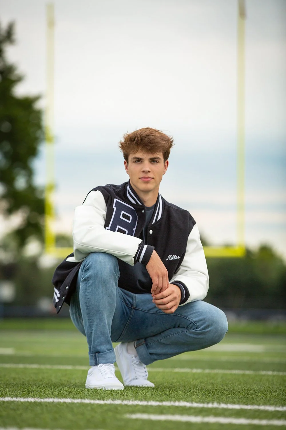 Athletic senior photography in Victor NY highlighting football player at stadium