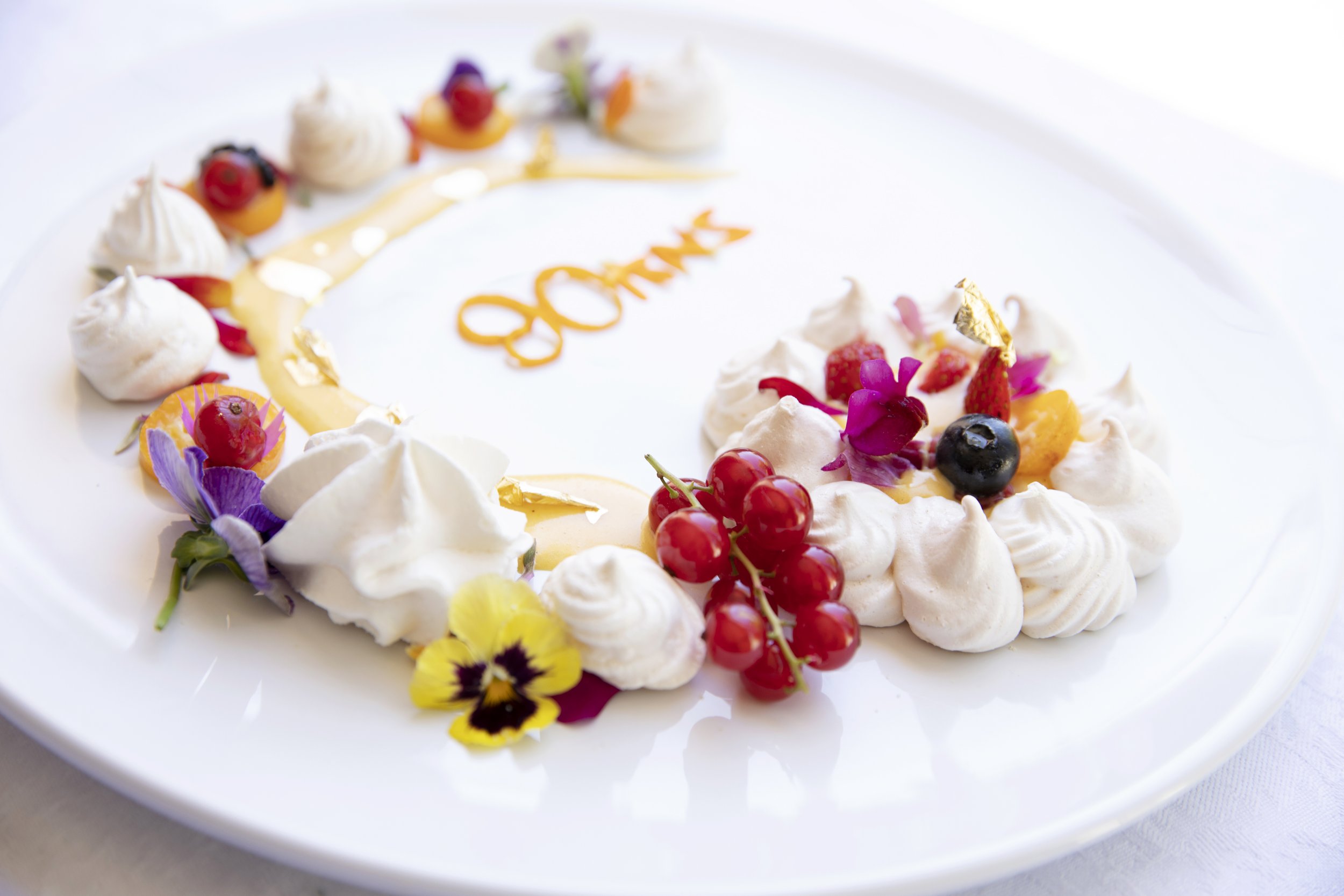   Deconstructed Pavlova with passion fruit curd, edible flowers, fresh berries and edible gold leaf.    Created for Les Vergers Boiron 80th Anniversary Book. Recipe and food styling by Tasha Powell.    Photo by Jill Paider  