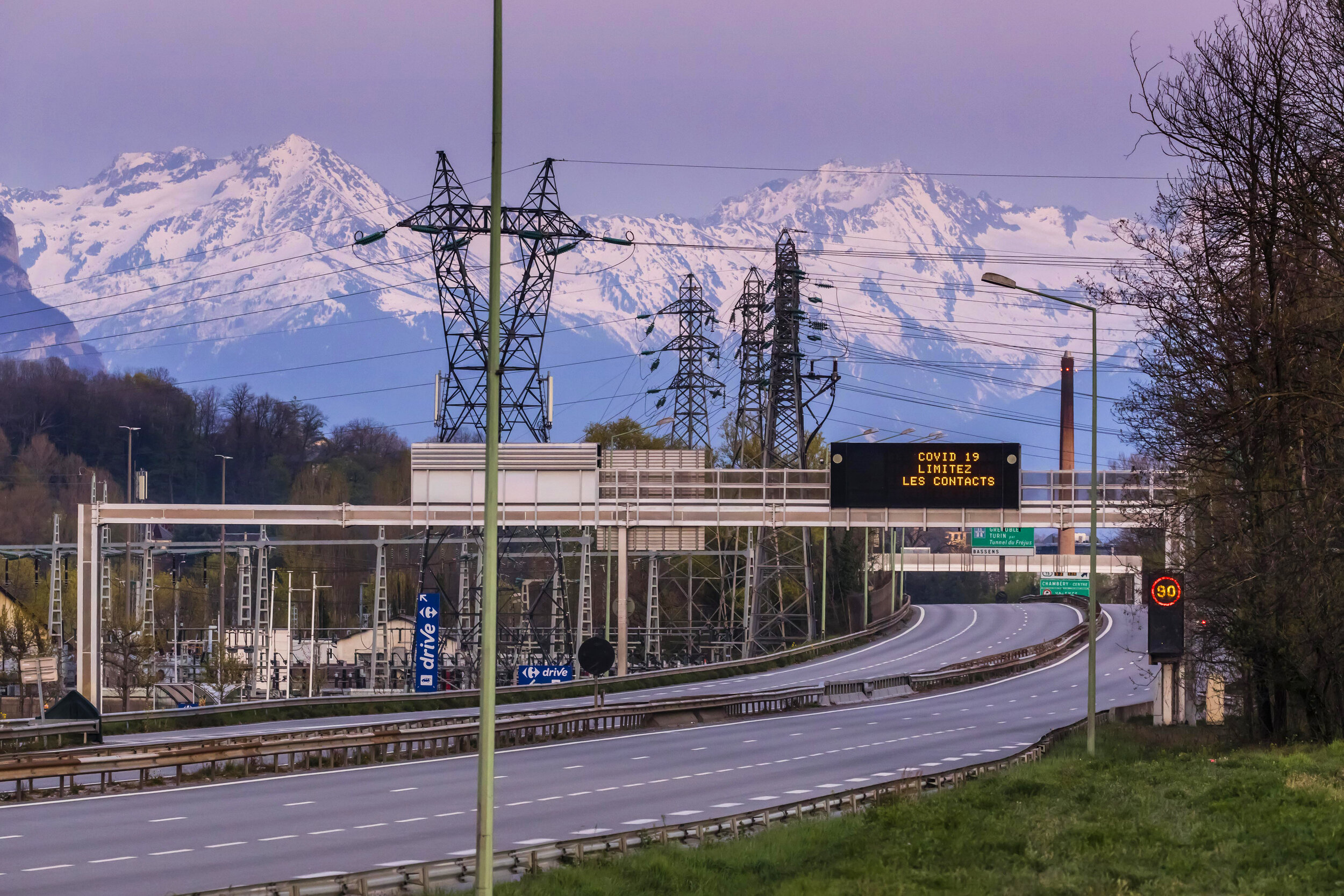   © Vincent Isoré / IP3 ; Chambery, France April 4, 2020 - An information panel reading "COVID19 limit contacts" on an empty urban expressway .  