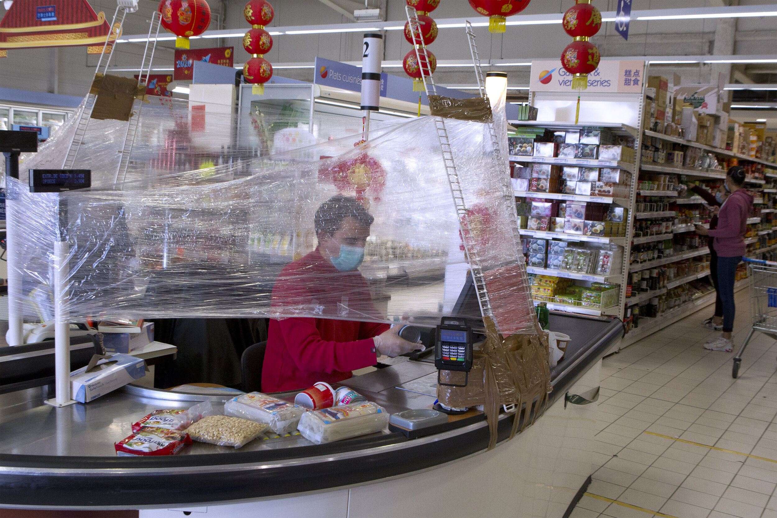   © Guillaume Bonnefont / IP3, Montpellier, France April 7, 2020 - A cashier is protected by plastic film to avoid contamination with customers during the coronavirus epidemic.  