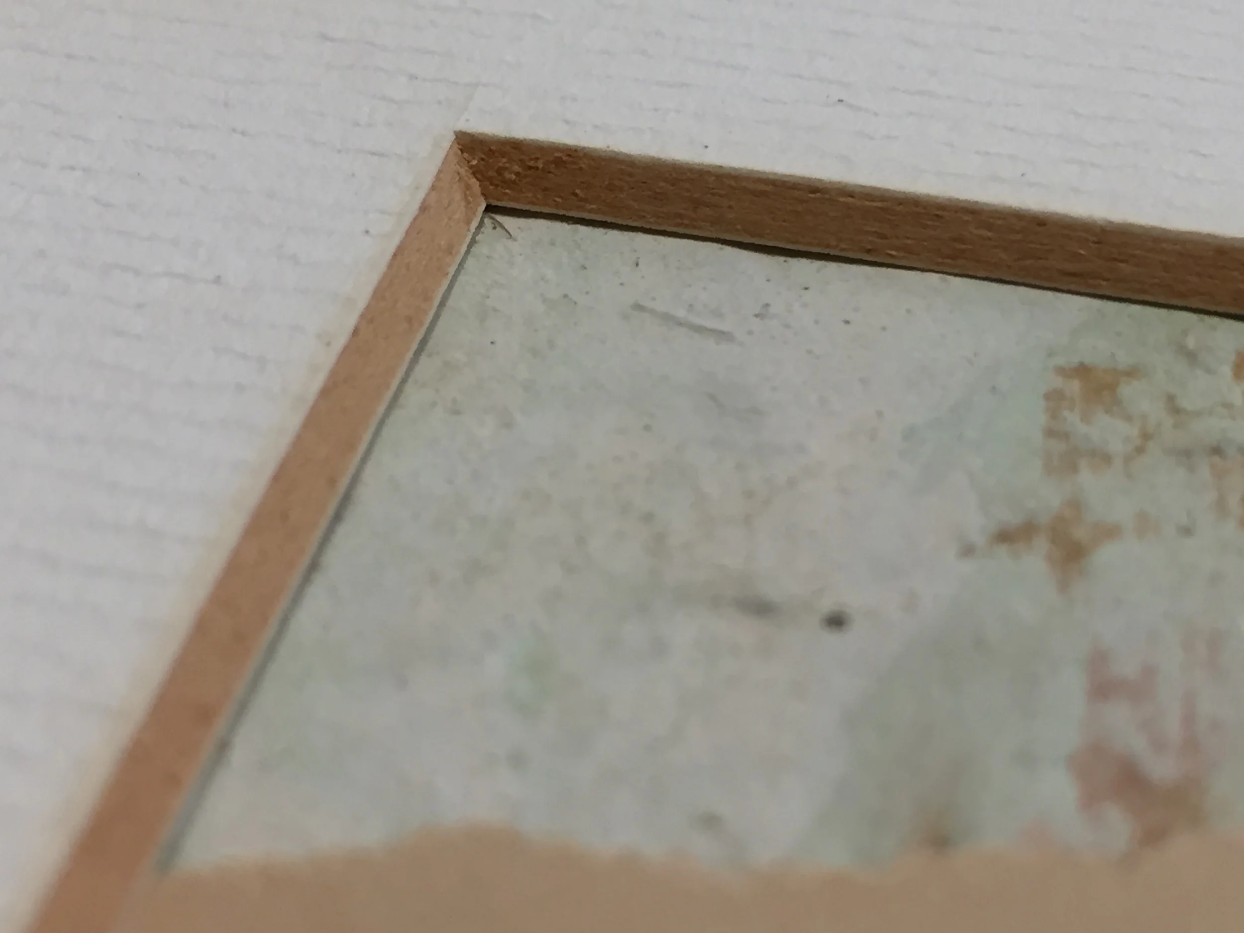 Discoloration in the matboard indicated by the darkened beveled edge is evidence that acid is present.