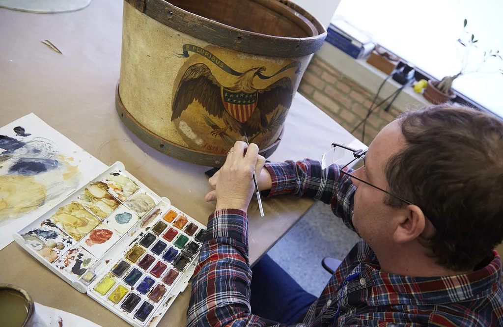 Reversible watercolor and acrylic conservation paints fill areas of loss within the drum.
