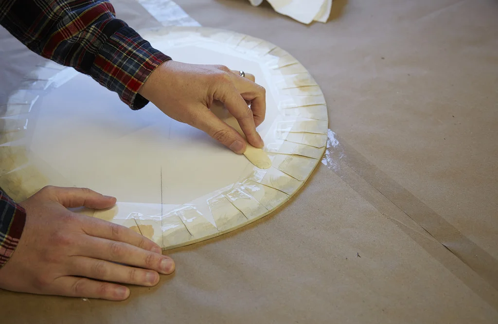 A new drum head is being created in preparation for exhibition.