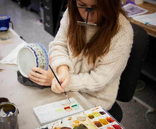 Sian inpaints the bowl with reversible paints.