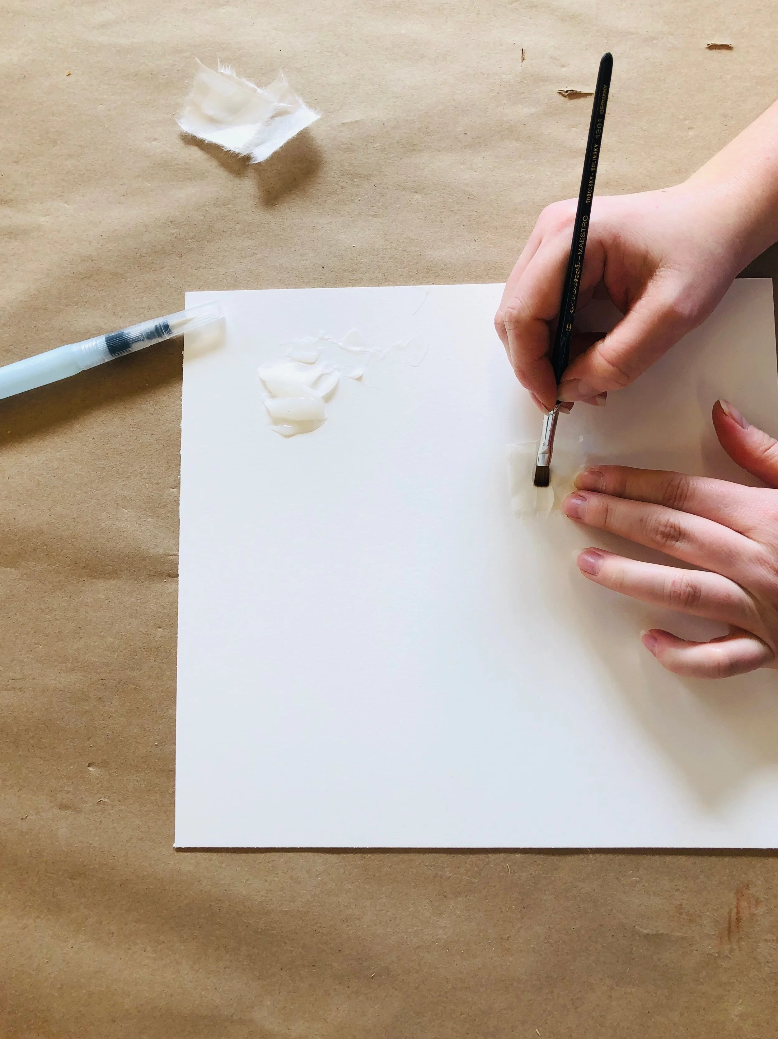 A Custom Framer applies the wheat starch paste to the Kozo paper in preparation of a V-hinge.