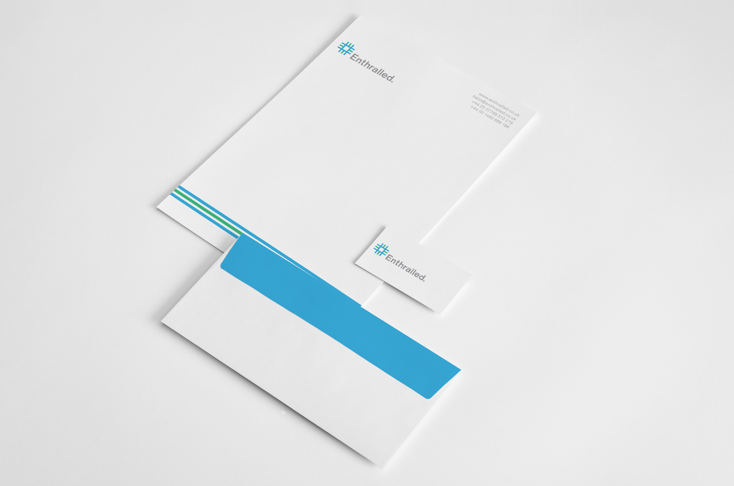 Mix of Enthralled branded white Brand identity designer UK - A4 paper, business card and envelope