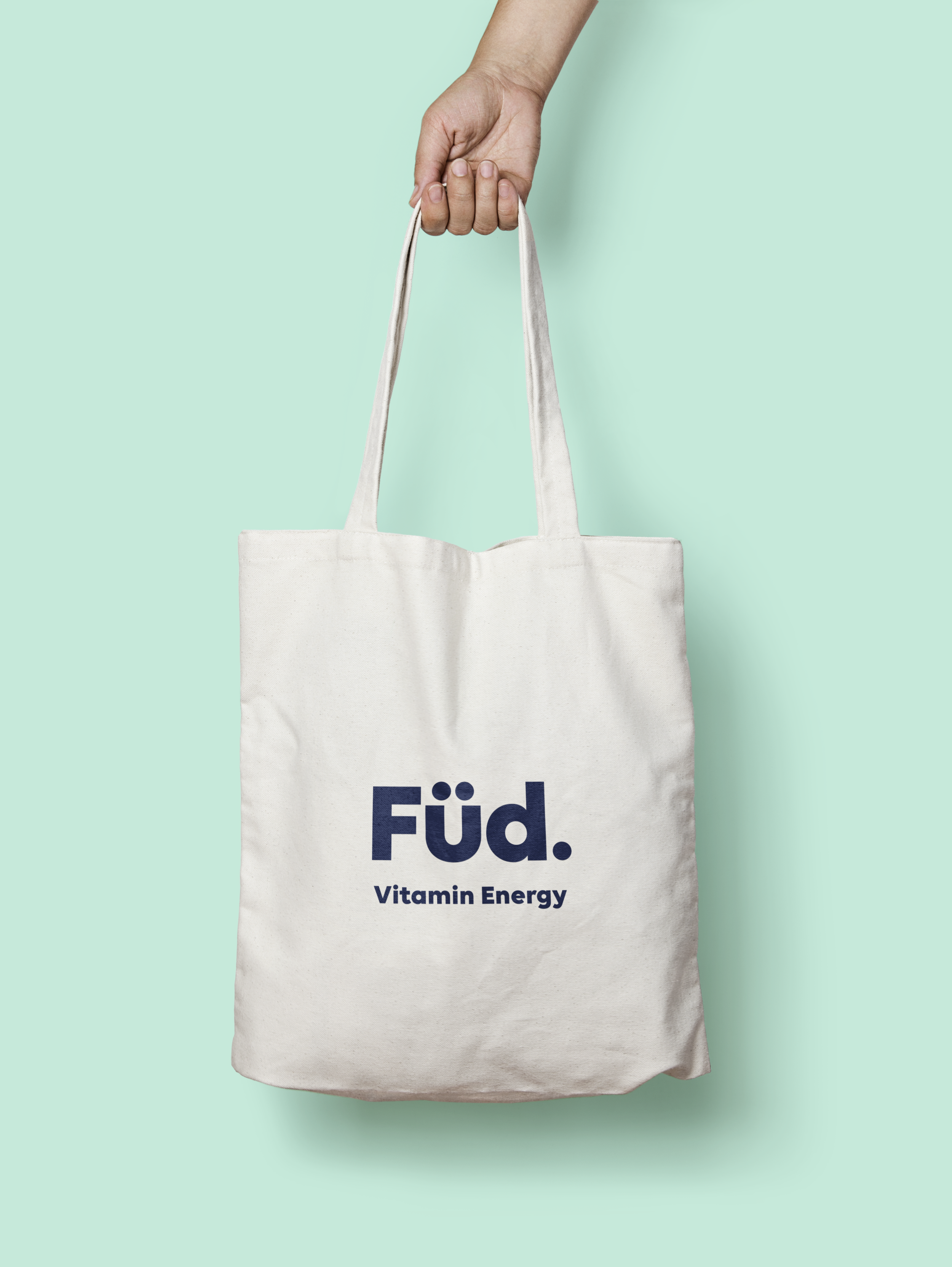 Food and beverage packaging designer UK. A hand holding a Füd white tote bag