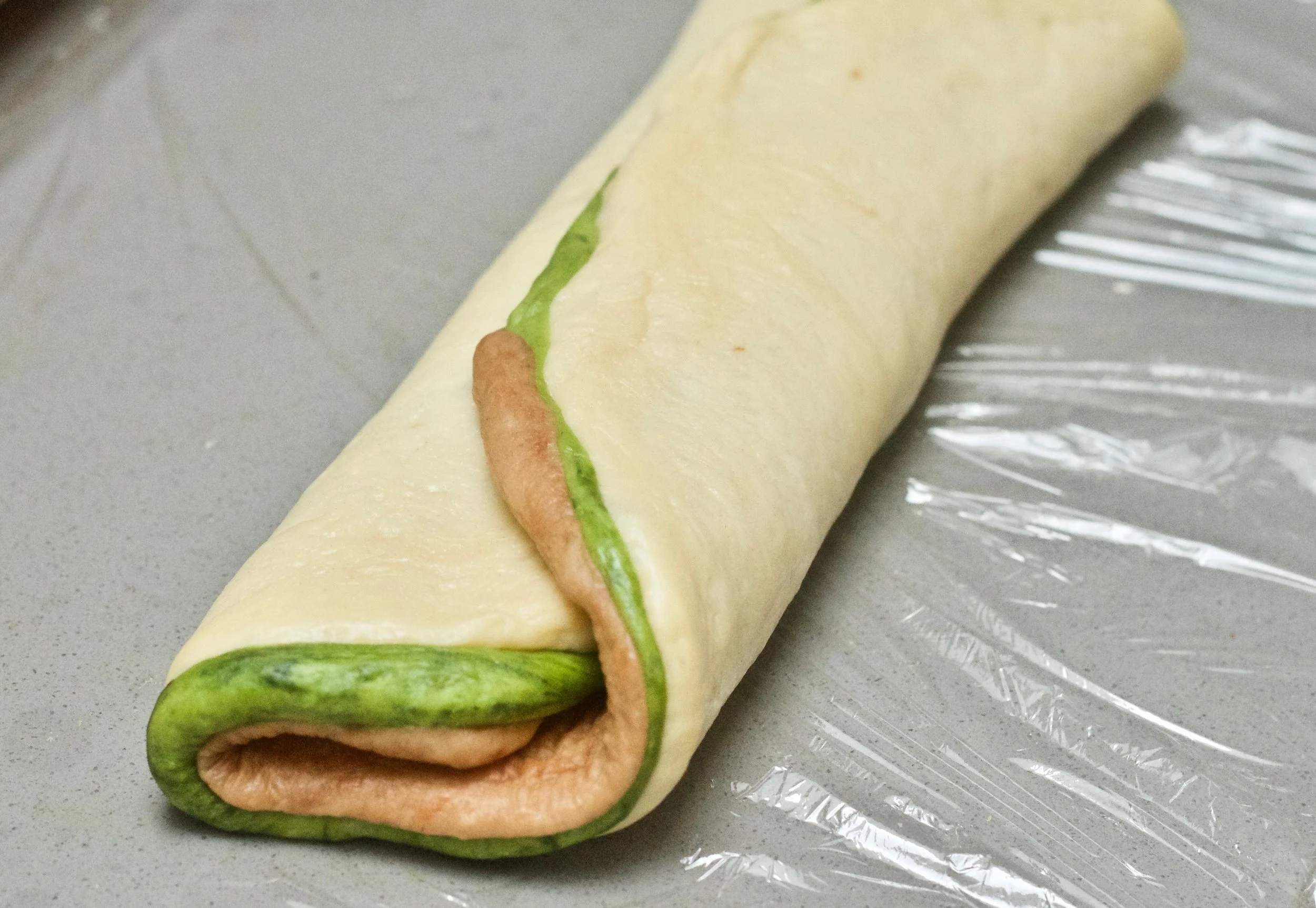 Take one short end of the dough and fold it to the center of the oval, then take the other end and fold to meet the top. This will look like a folded letter.