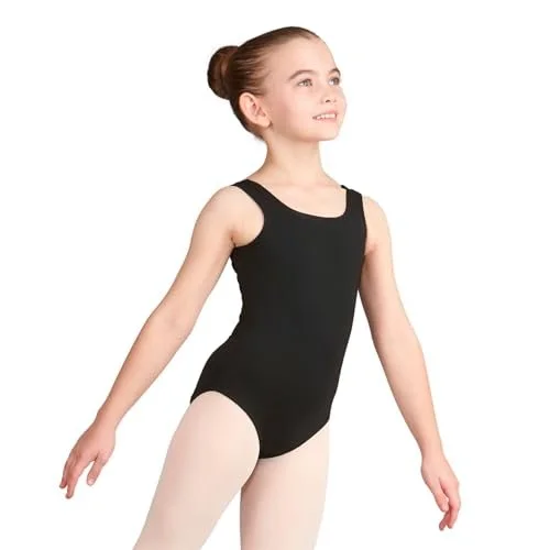 Young girl in a black leotard and white tights poses with both arms slightly lowered and smiling.