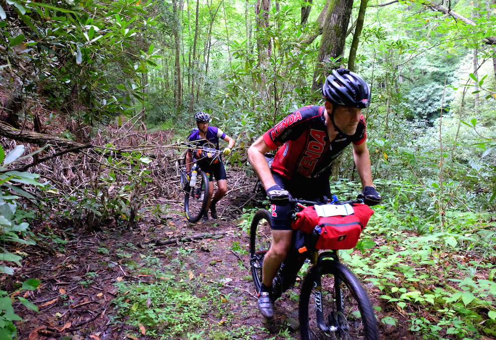 Riders push through debris and fallen trees near the start.