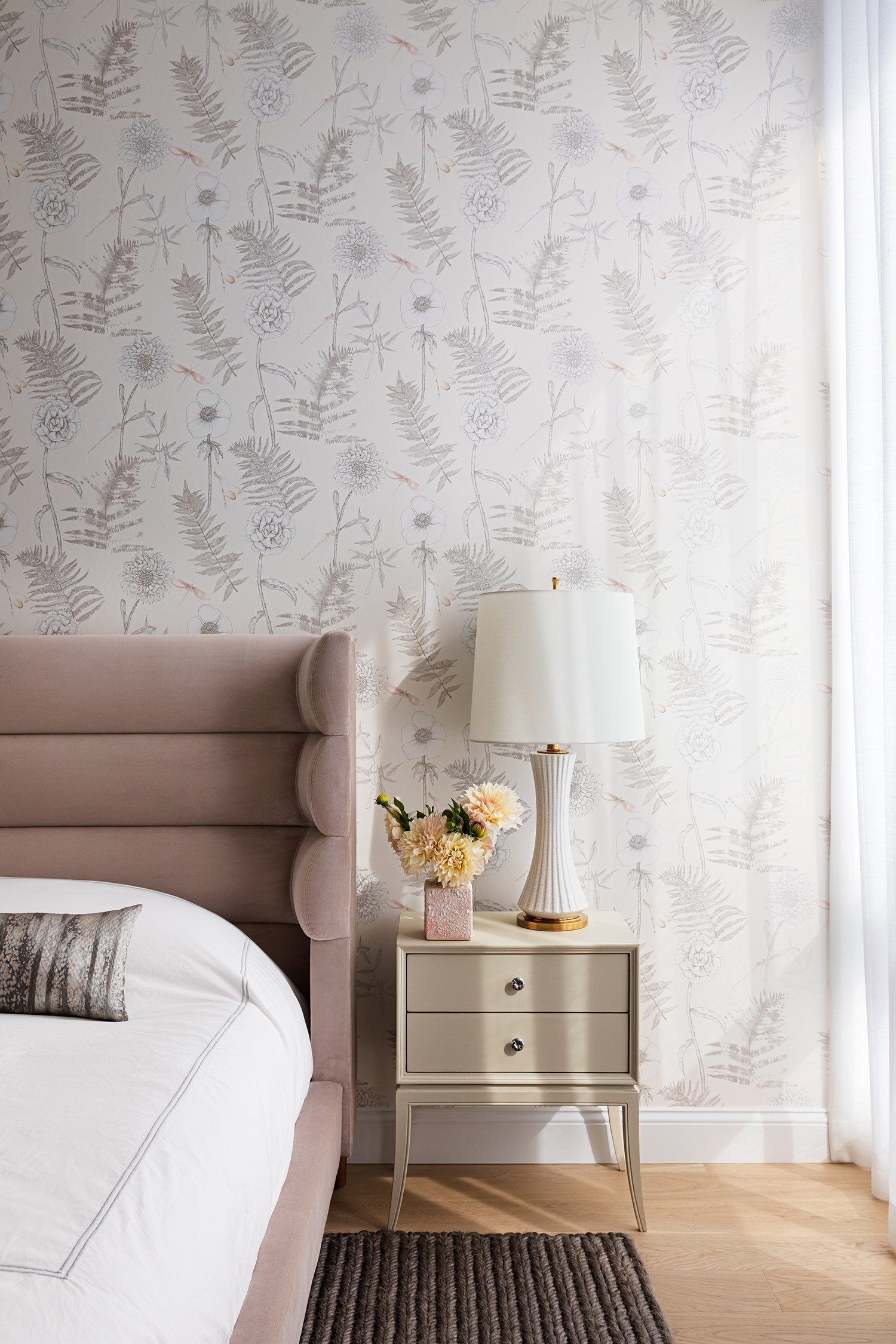  The guest room is sheathed in a soft floral wallpaper where tension is created with the rough texture of this sea grass rug against both the wall covering and the soft velvet of the bed. 