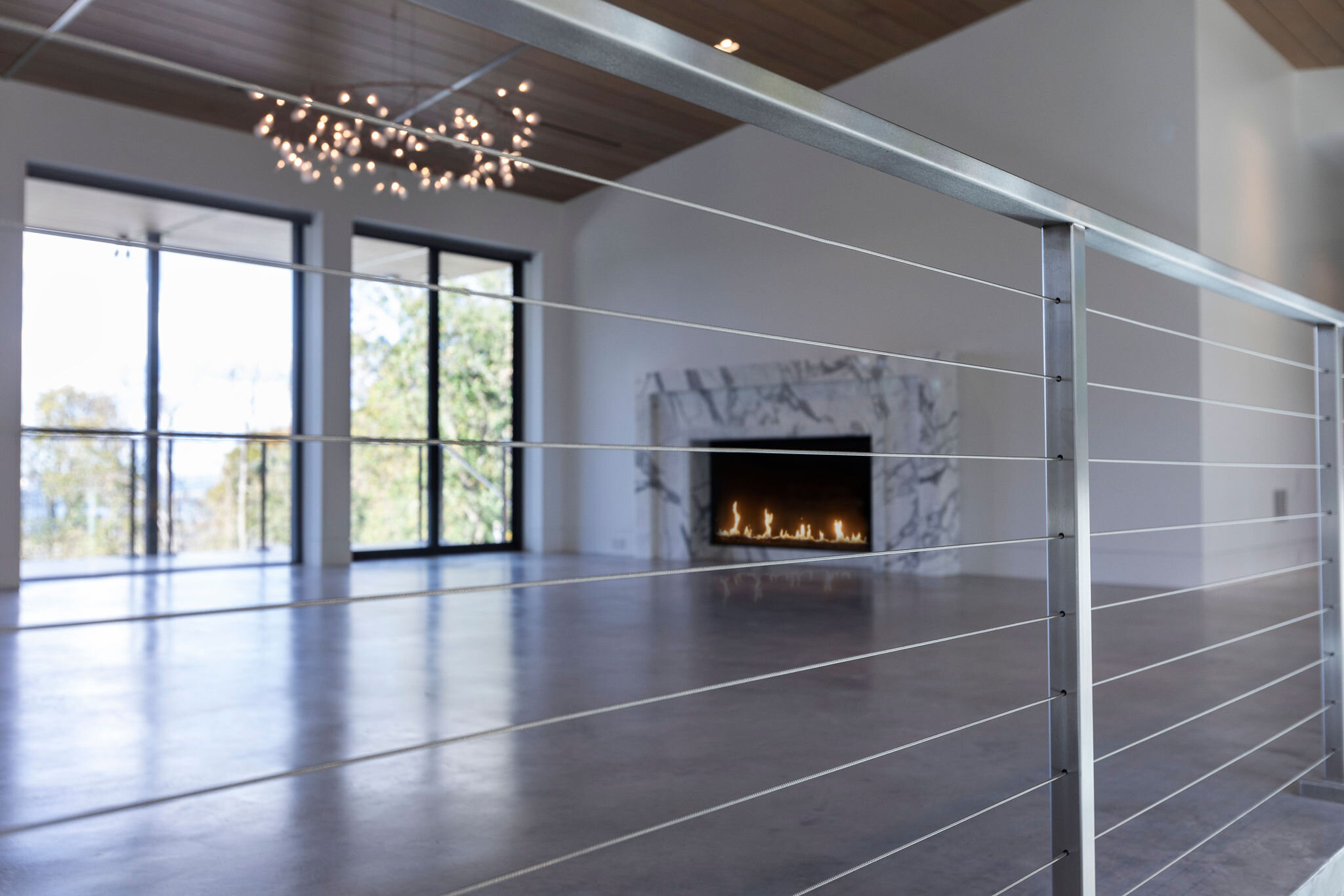  Poured concrete floors with a blazing fire welcome you into the new living room. We designed this home with a Zen sensibility marrying the inside with the outdoors. 