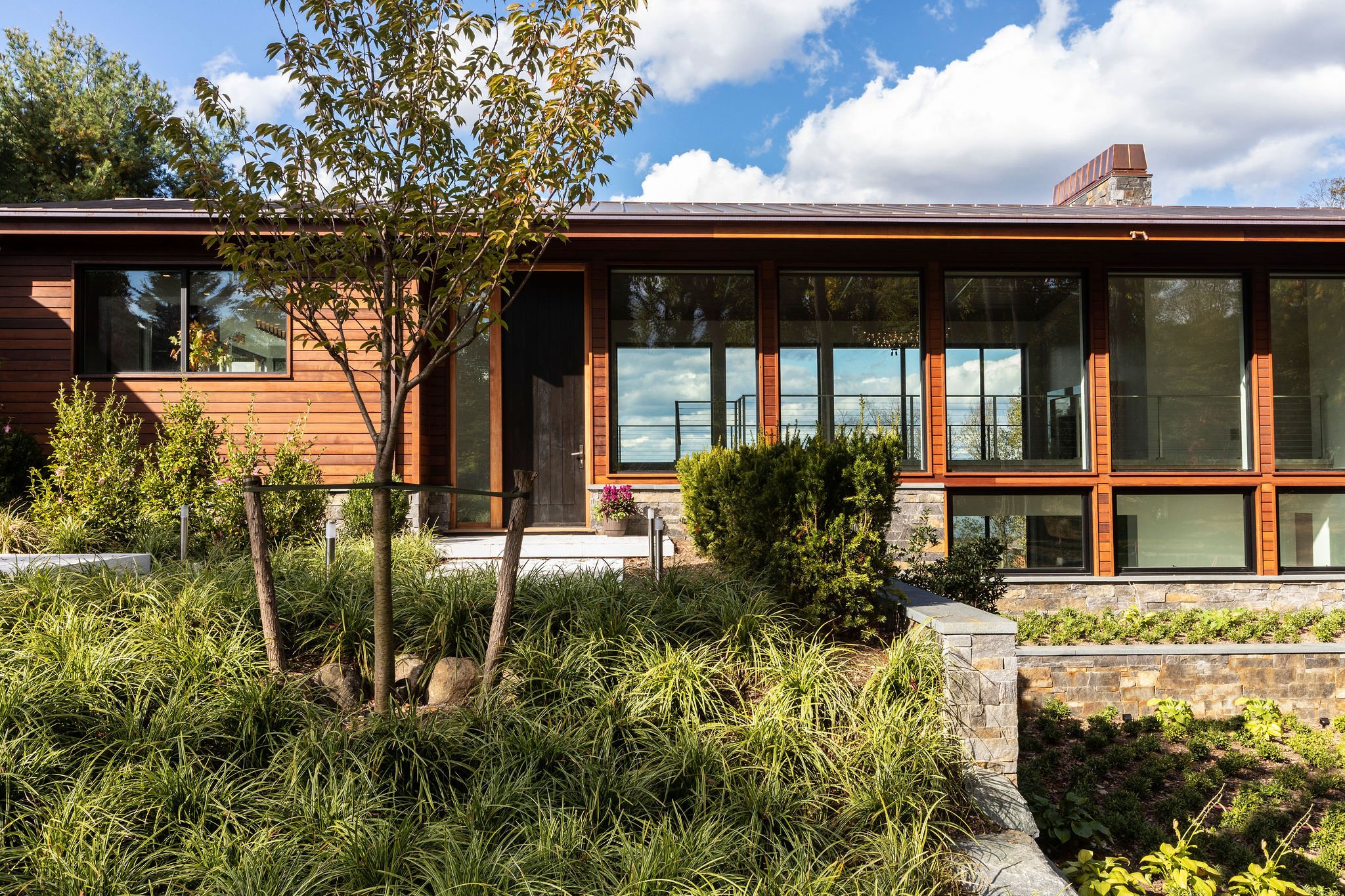  Blackened steel windows, huge stone multi-colored walls, wood siding and copper details were all designed to give this house a sense of 21st century modernism. 