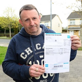 Michael Murtagh holds up a water bill that daughter Michelle received despite living in Canada for two years