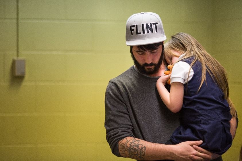 Matt Hopper holds and comforts Nyla Hopper, age 5, after she has her blood drawn to be tested for lead on January 26, 2016 in Flint, Michigan