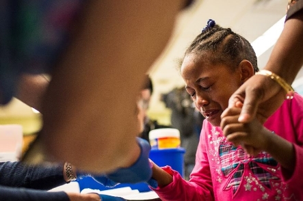 Tears stream down the face of Morgan Walker, 5, as she gets her finger pricked for a lead screening on January 26, 2016 in Flint, Michigan