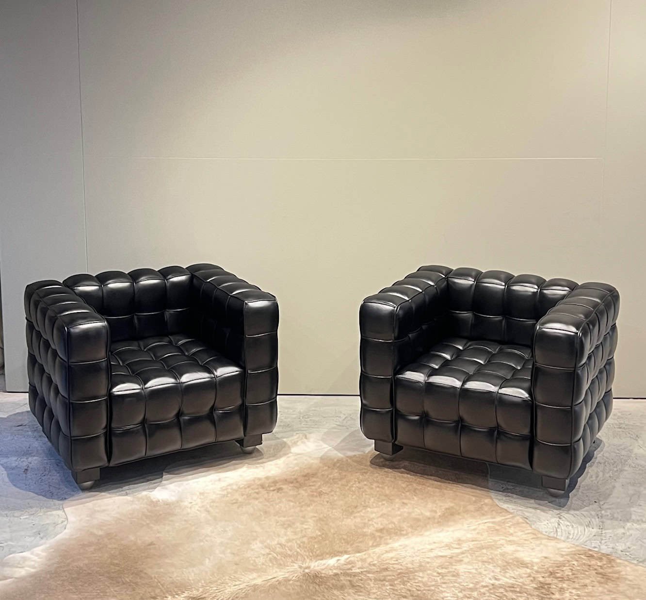 pair of black leather quilted lounge chairs.jpeg