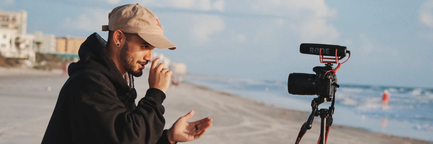 man on beach talking to camera