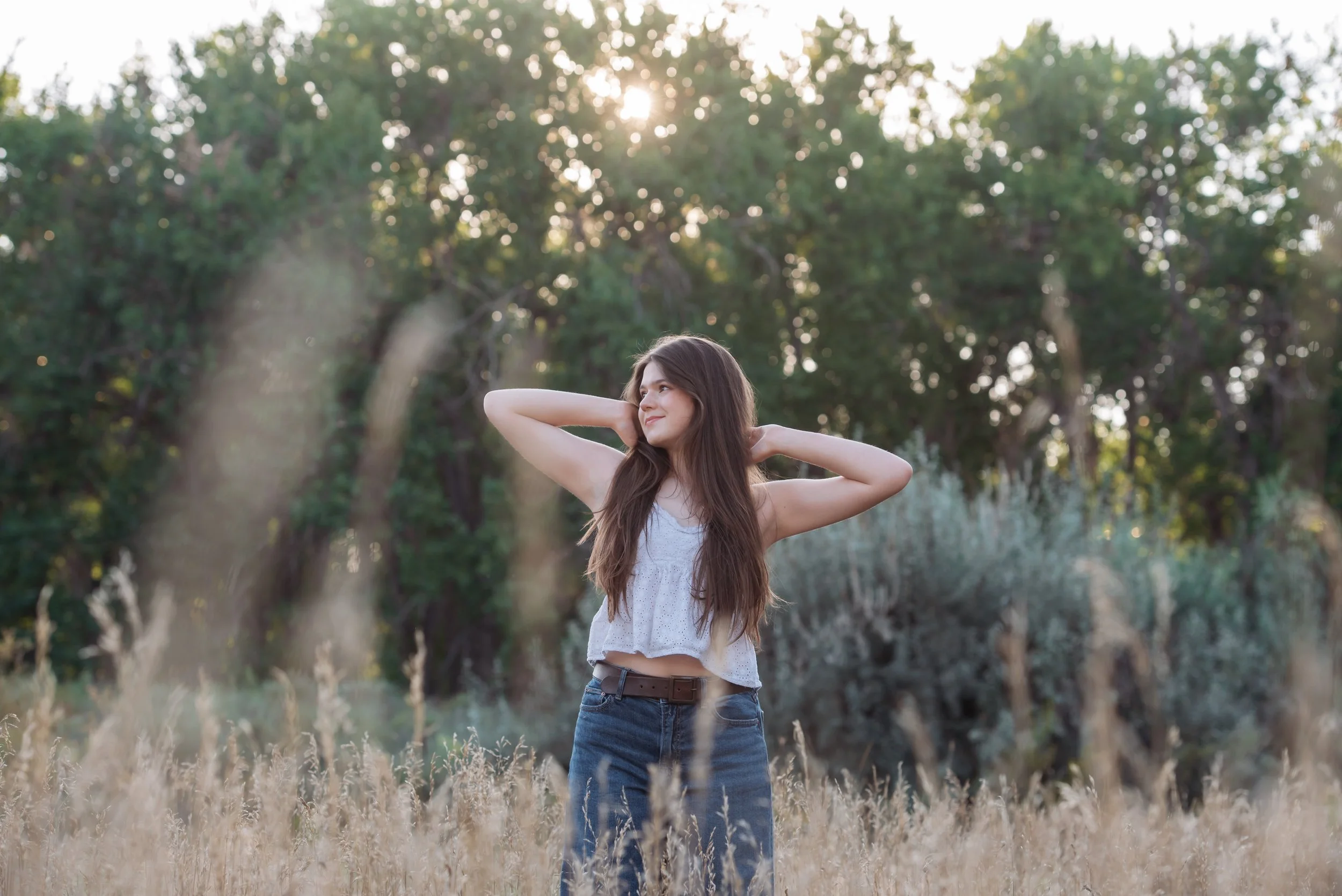 Brown Haired Senior girl smiles in the Colorado open space during her Parker Senior Photos