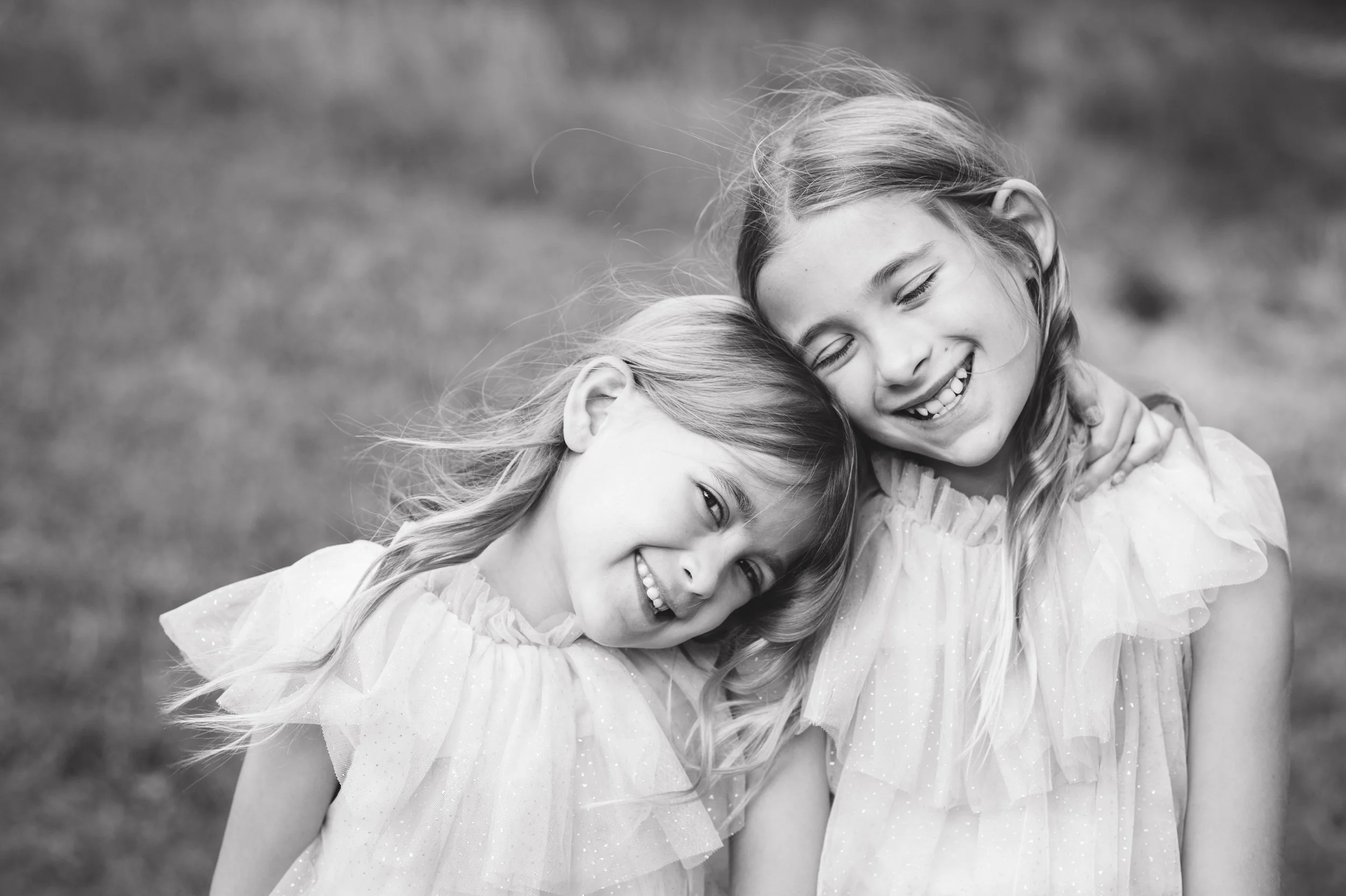2 sisters pose together smiling for family photos in Cherry Hills Village