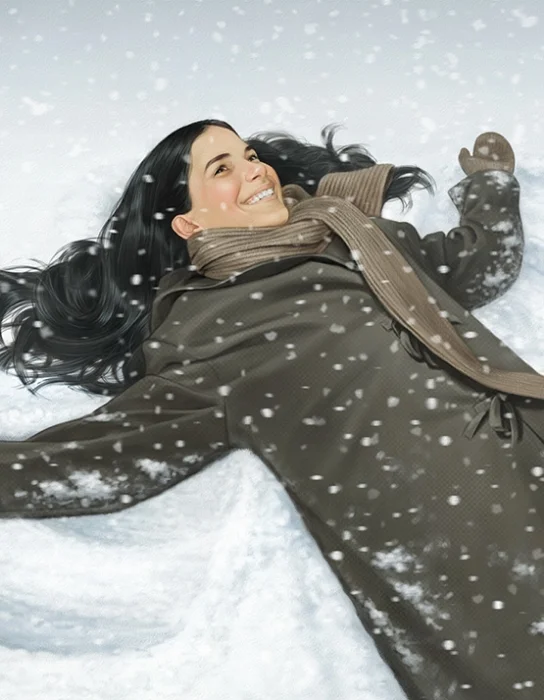 A woman with long dark hair lying on her back in the snow, smiling, with snow falling around her, wearing a brown coat and scarf.