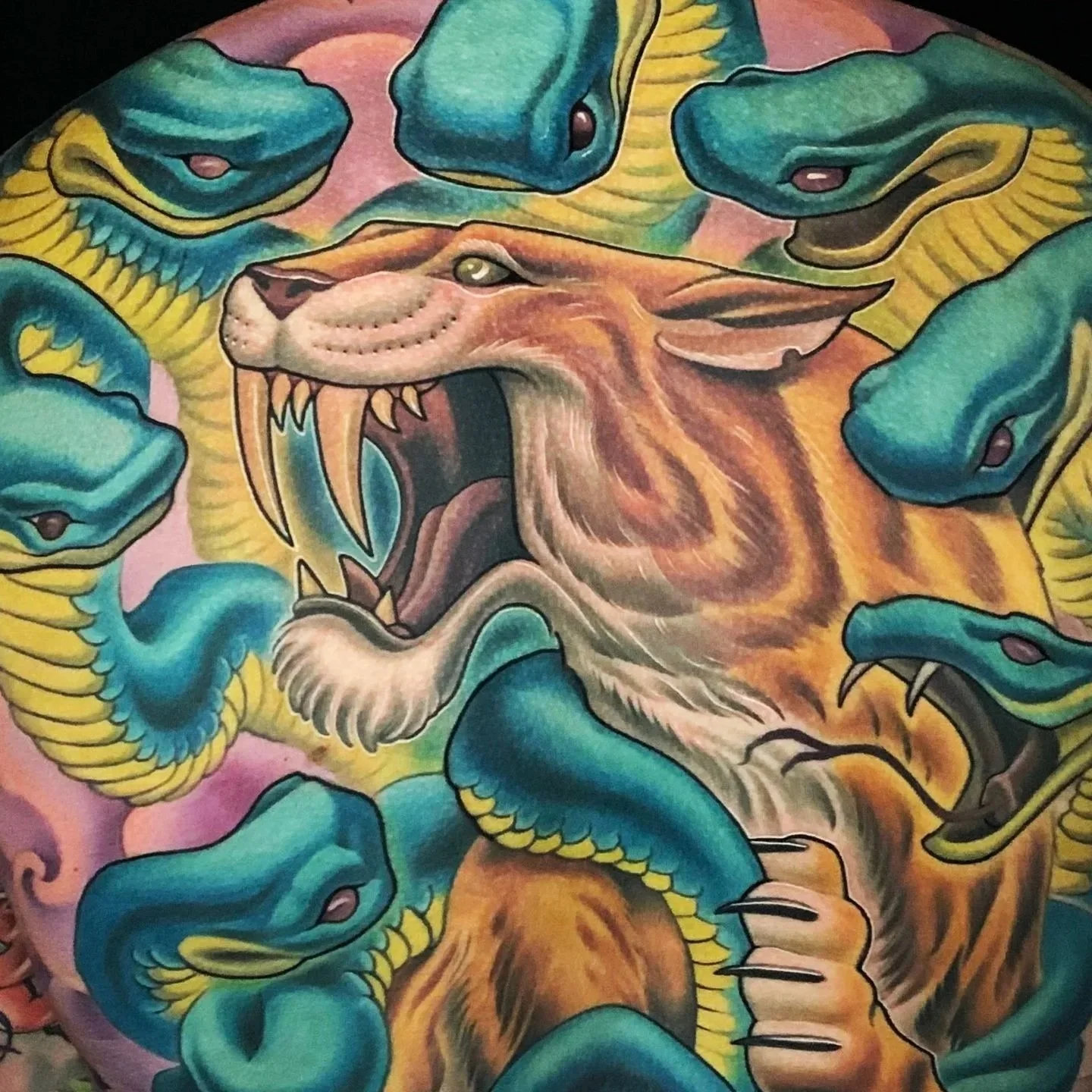 Saber tooth cat and snakes backpiece tattoo