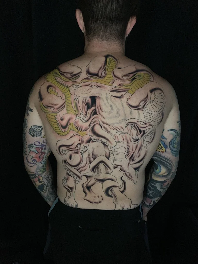 Saber tooth cat and snakes backpiece tattoo 